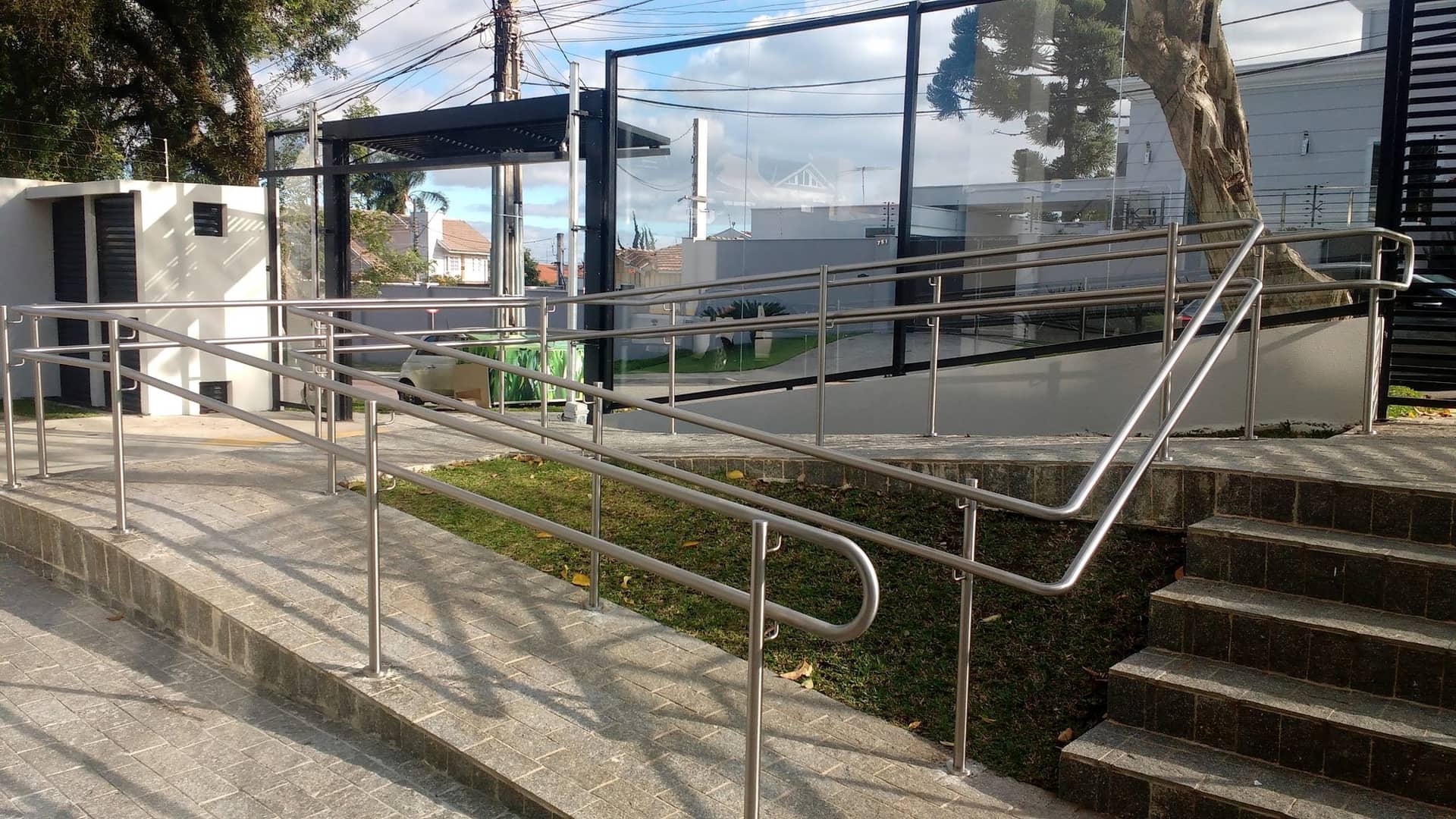 Rampa com corrimão duplo em inox ao lado da escada