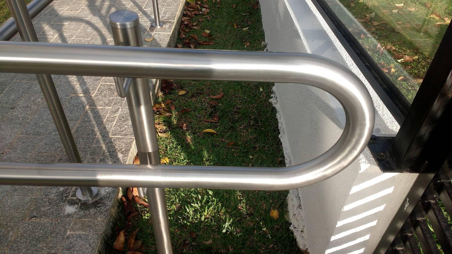 Detalhe da ponta curva do corrimão em inox