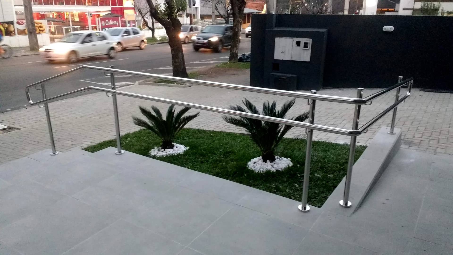 Rampa de acesso entre jardins com corrimão em inox em duas alturas