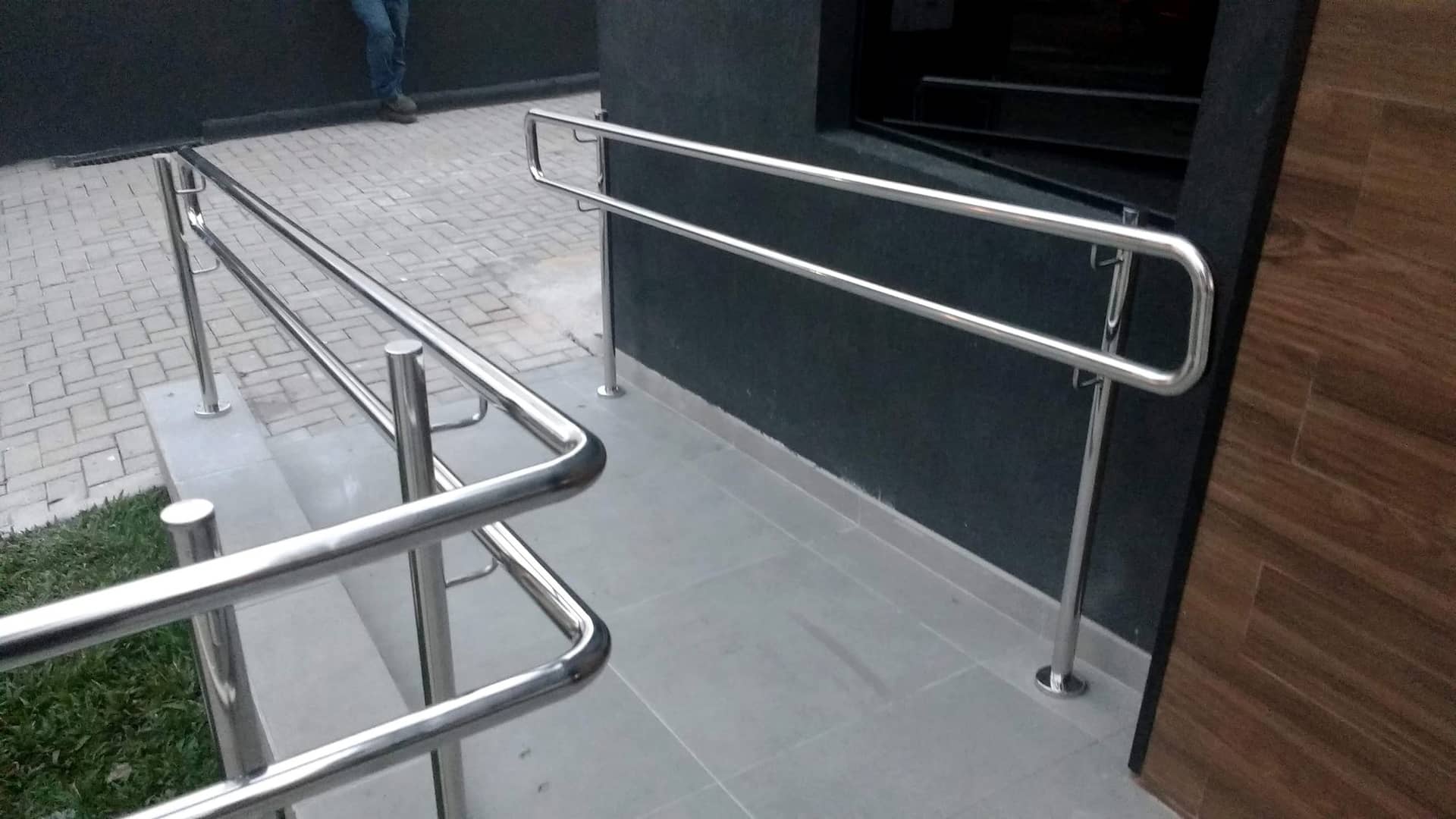 Corrimão em inox com pontas curvas junto à entrada