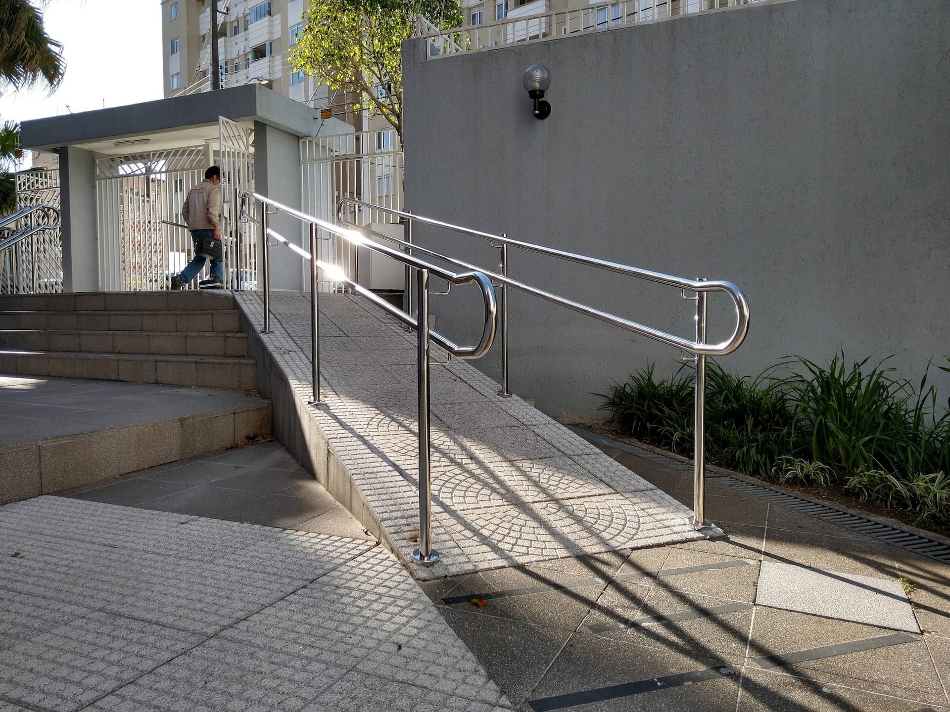 Rampa da área comum do condomínio com corrimão duplo em inox