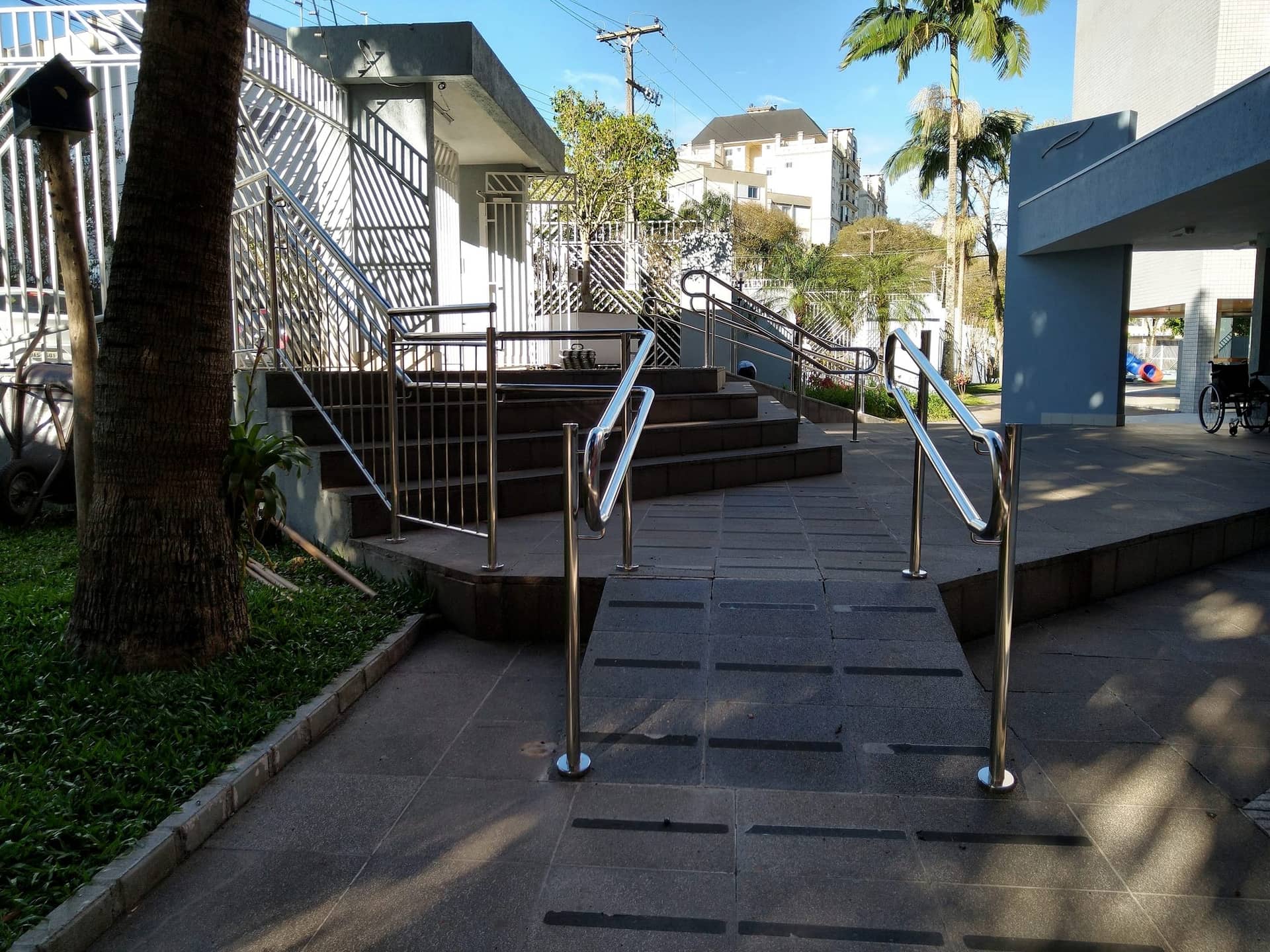 Rampa central com corrimãos em inox dos dois lados no acesso ao condomínio