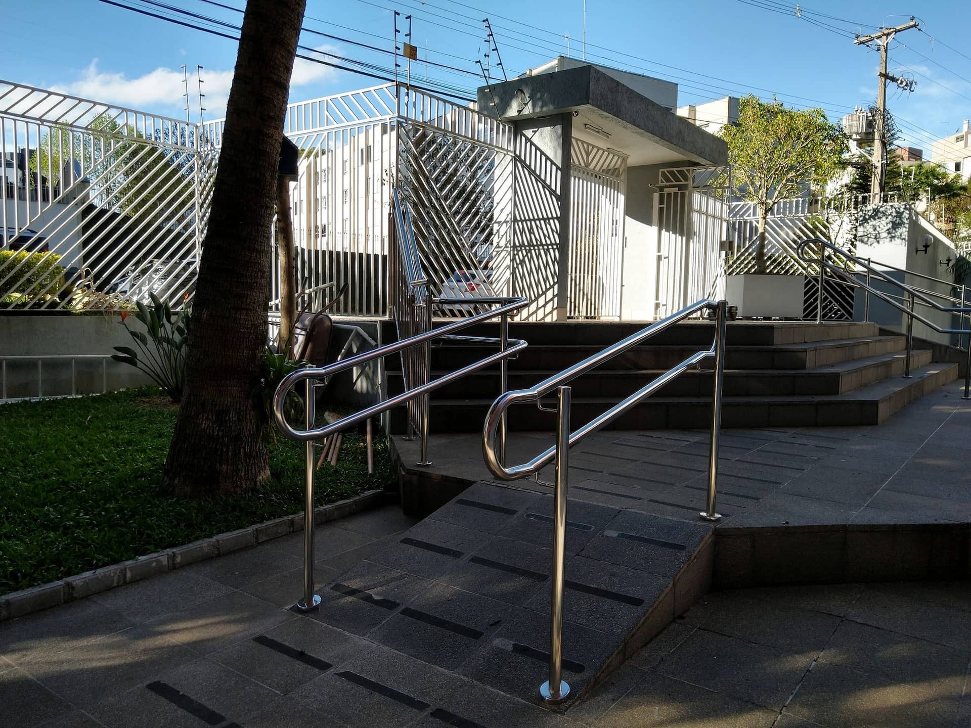 Rampa com corrimão em inox ao lado do jardim