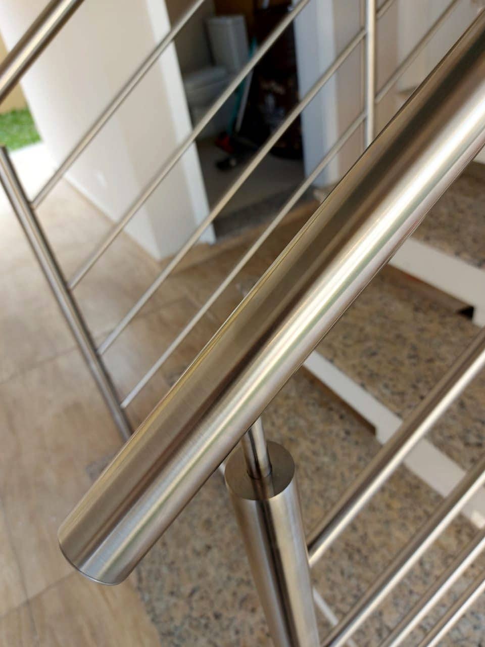 Detalhe do corrimão tubular em inox sobre as hastes horizontais