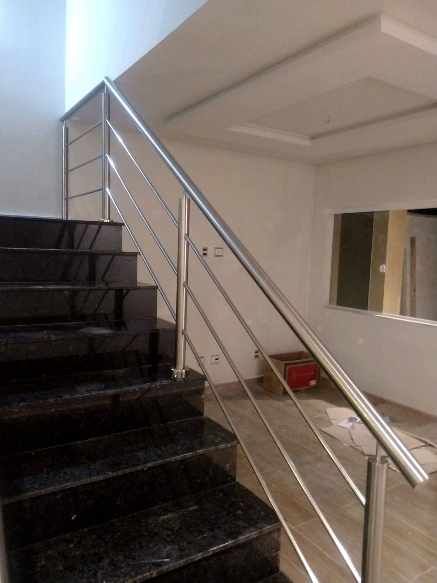 Lance de escada em granito preto com guarda-corpo de hastes em inox