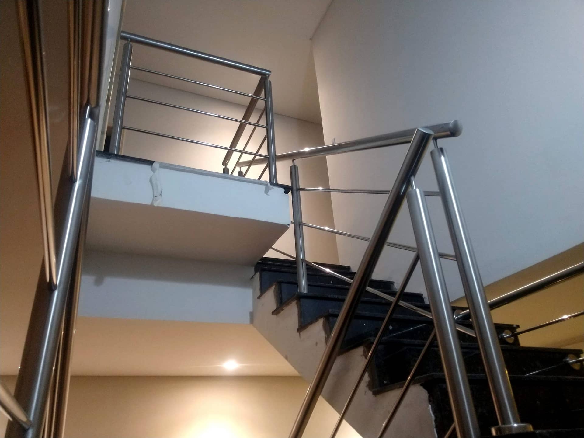 Fechamento do vão da escada com hastes horizontais em inox, visto de baixo