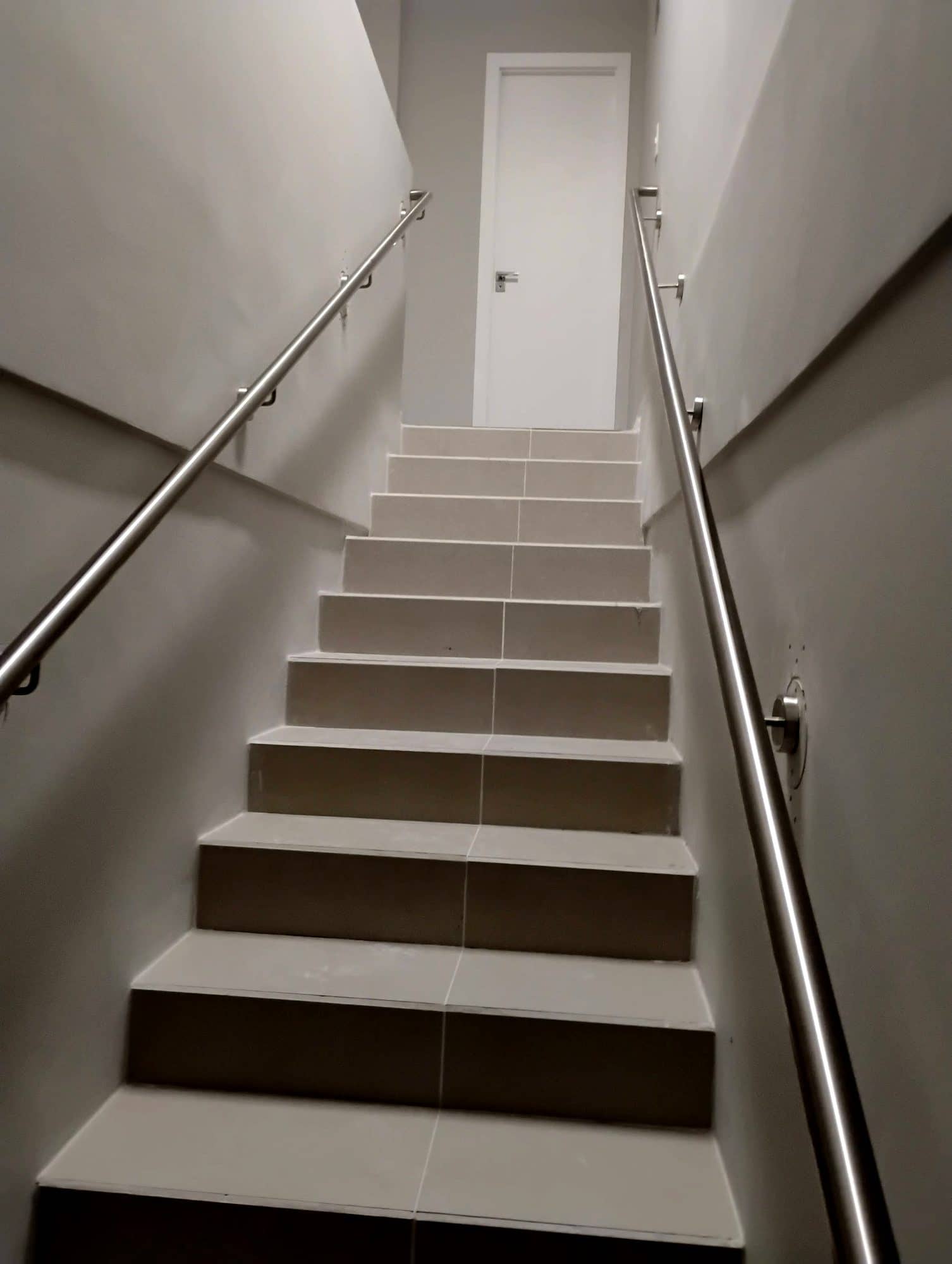 Escada interna com corrimão em inox fixado na parede dos dois lados