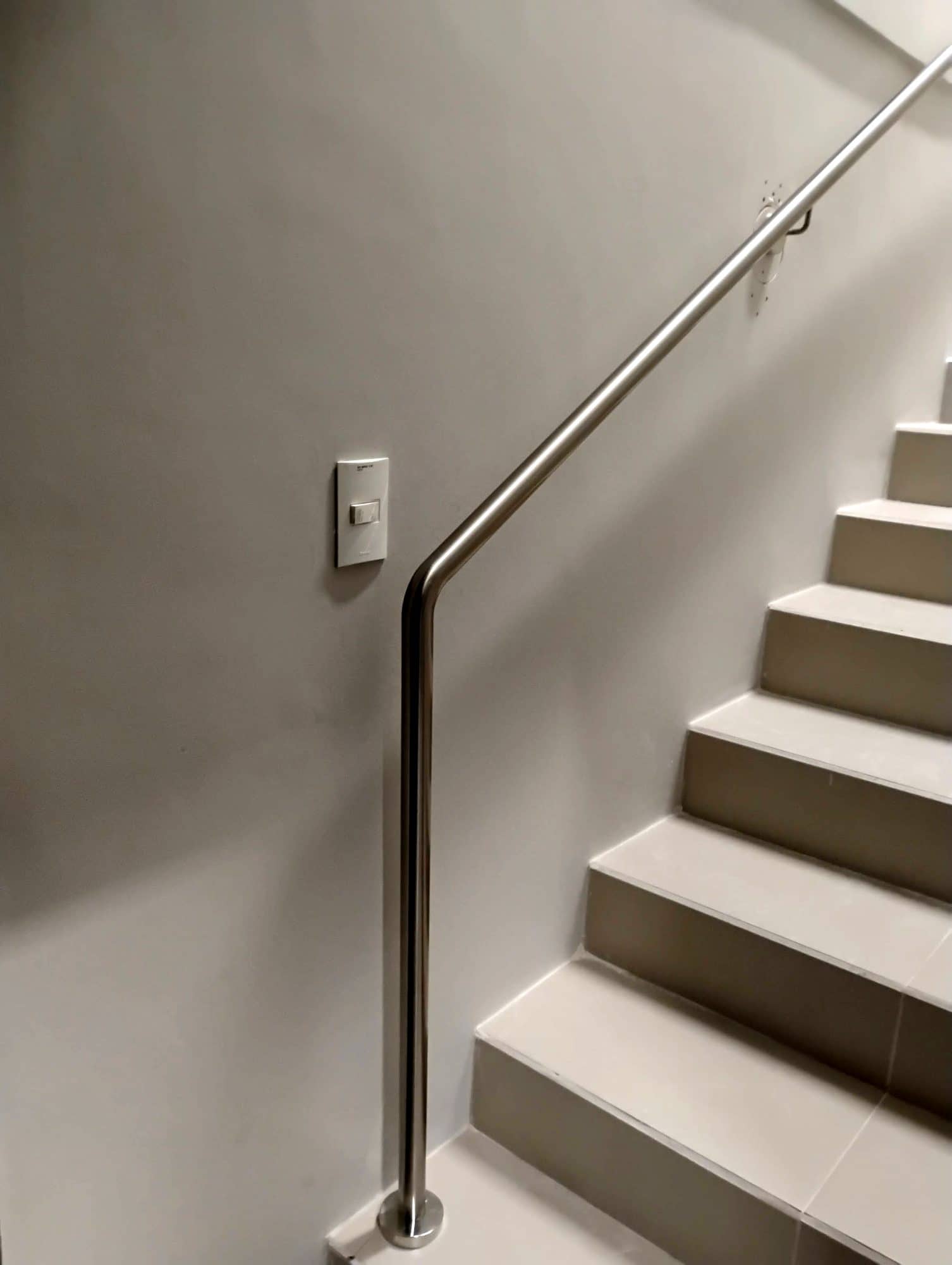 Corrimão de parede em inox descendo até o primeiro degrau