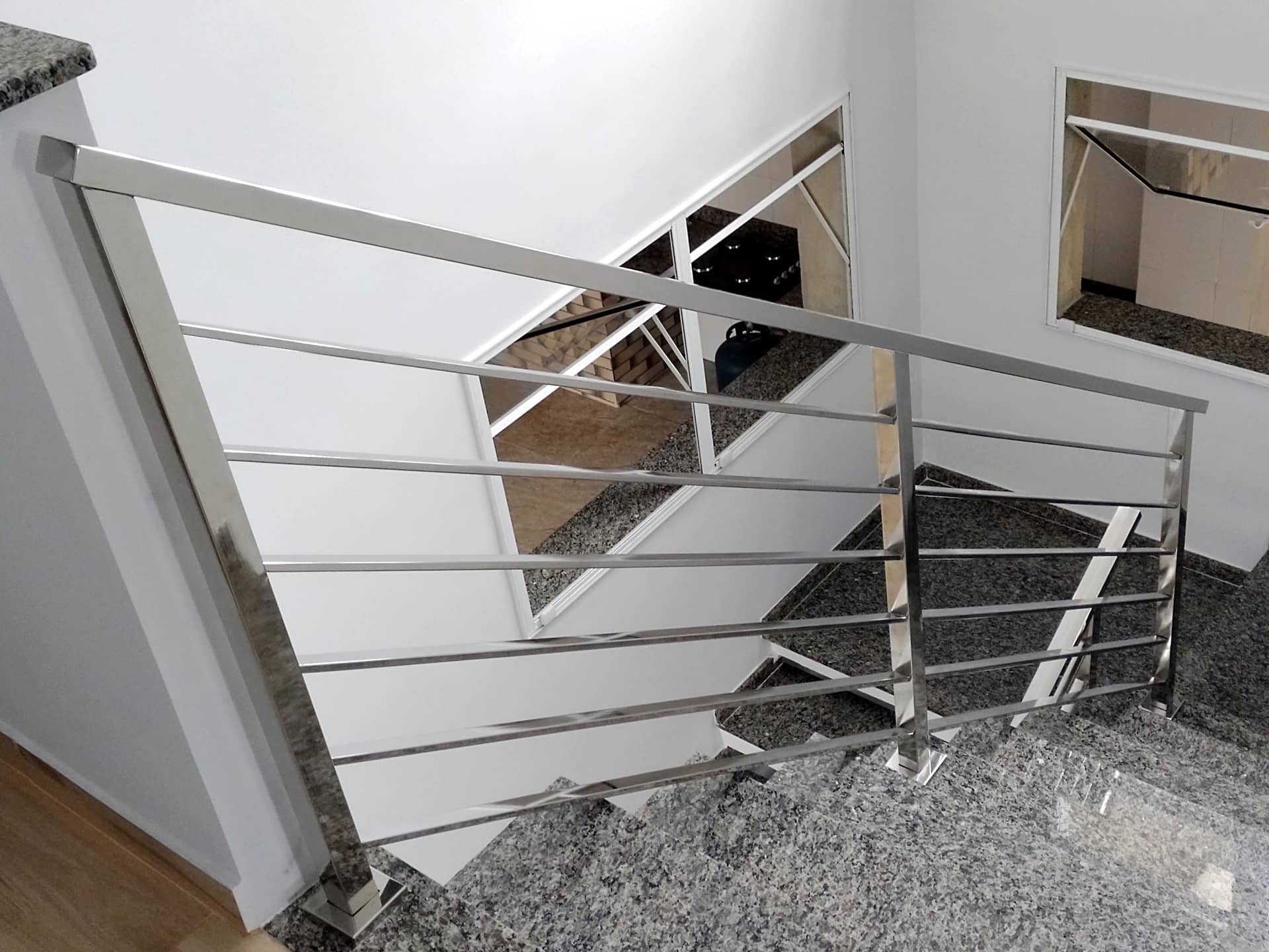 Fechamento do vão da escada com tubo quadrado em inox polido no pavimento superior