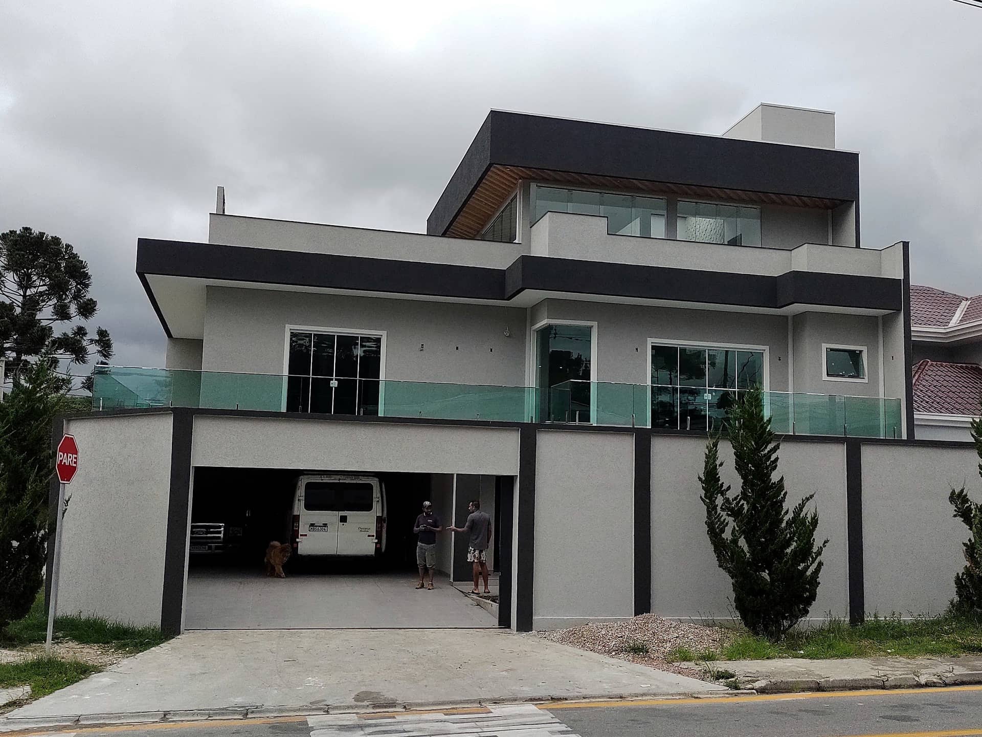 Fachada da casa com guarda-corpo de vidro verde ao longo do pavimento superior