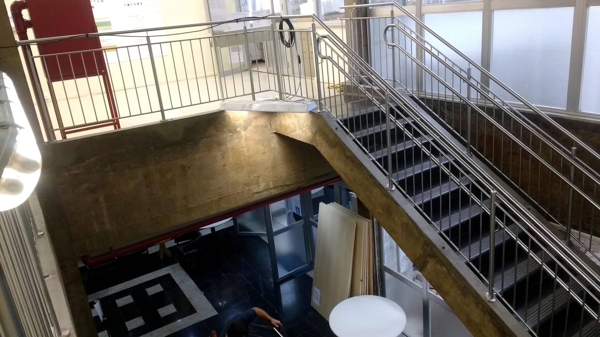 Escadaria com guarda-corpo de inox vista do pavimento superior