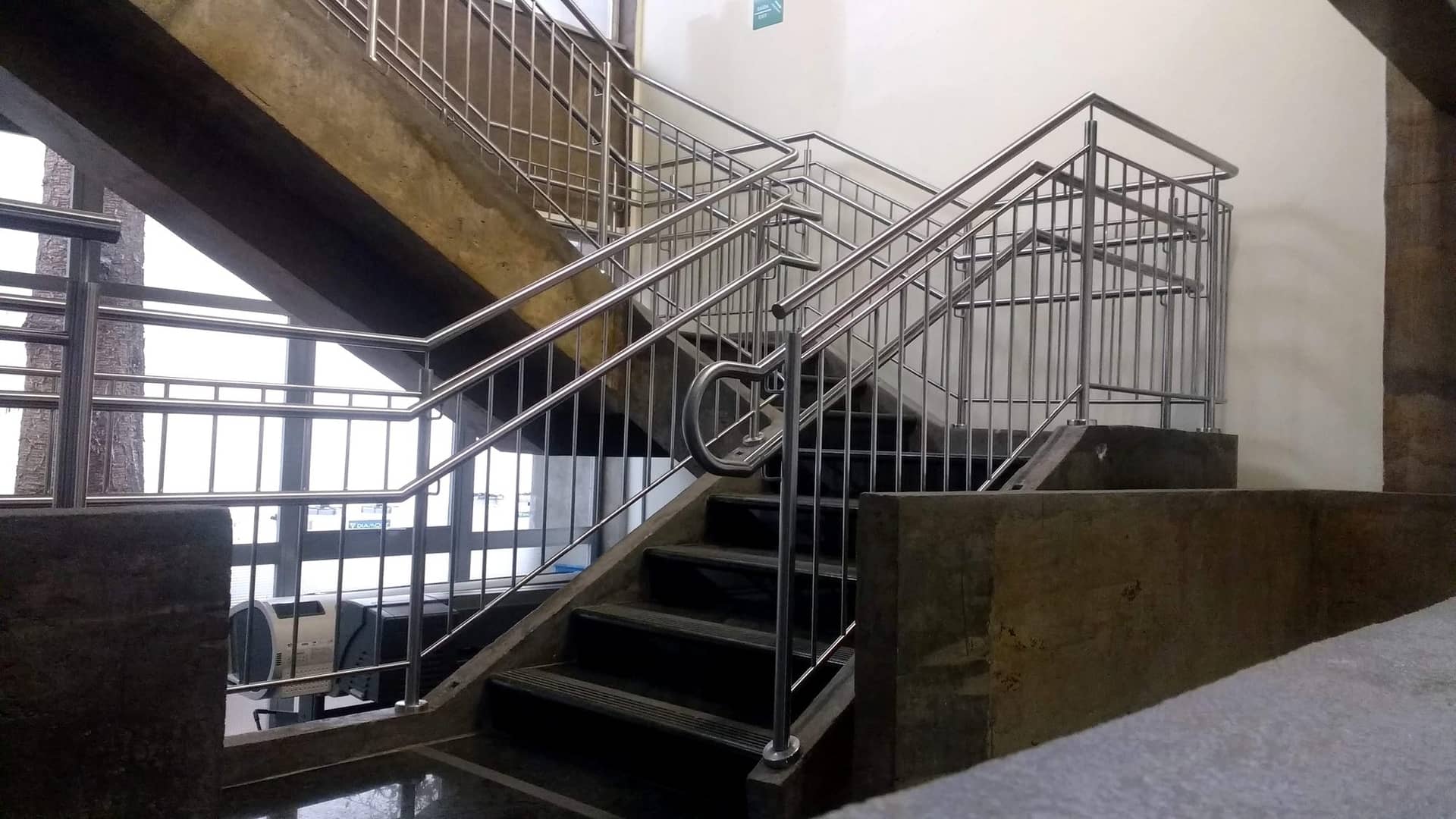Lance da escadaria com corrimão em inox e guarda-corpo de travessas verticais