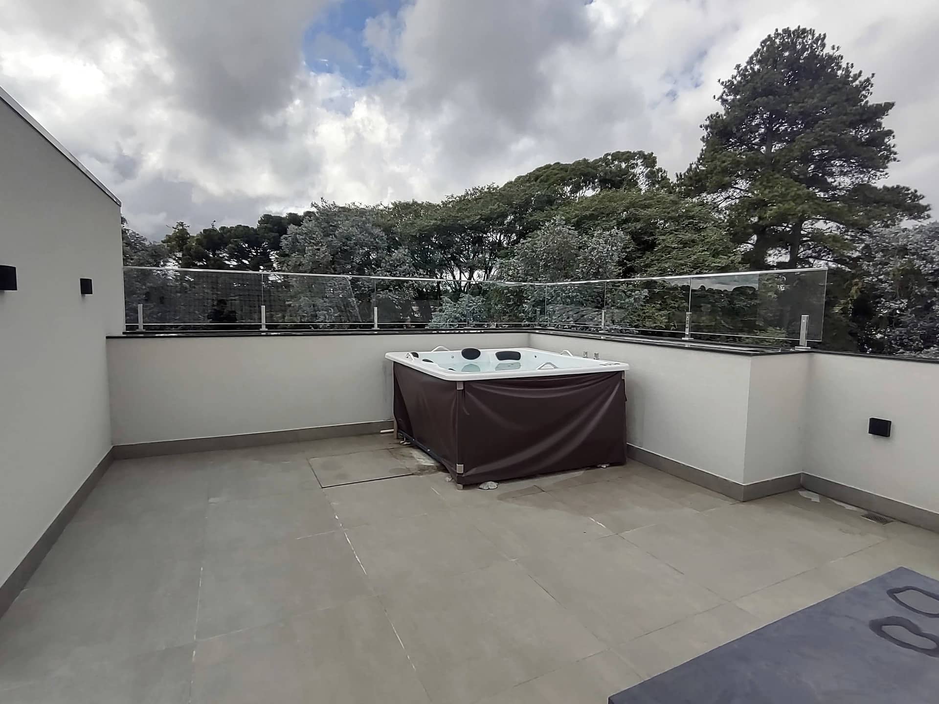 Cobertura com spa e guarda-corpo de vidro em todo o contorno