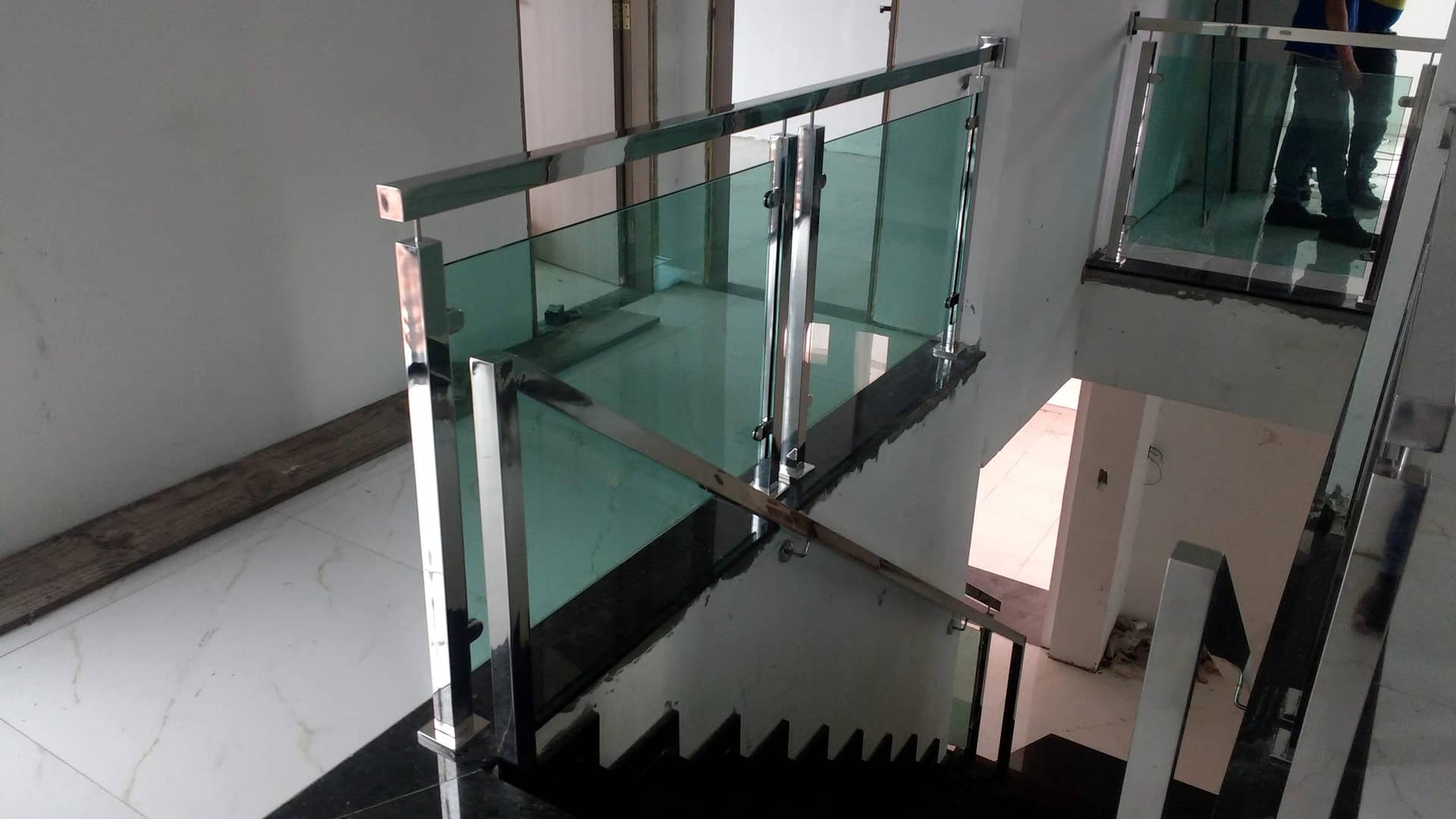Guarda-corpo tubular em inox com vidro verde ao redor da escada