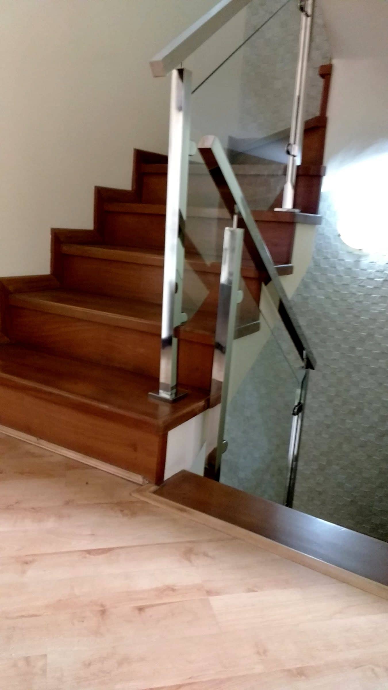 Escada de madeira com guarda-corpo de vidro e corrimão em inox