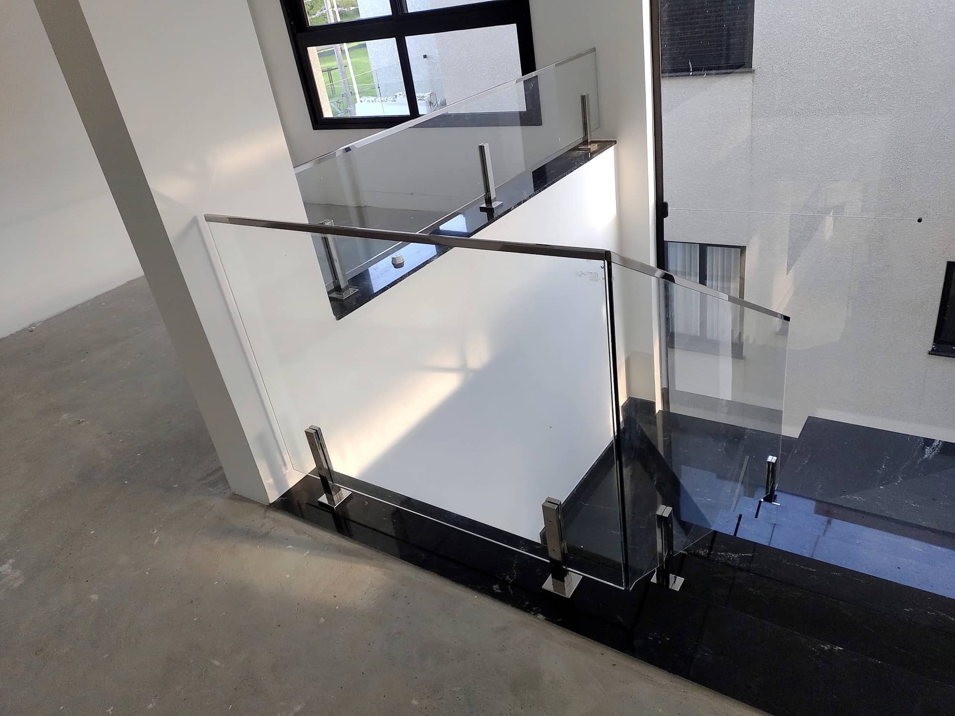 Fechamento do vão da escada com vidro e colunas em inox