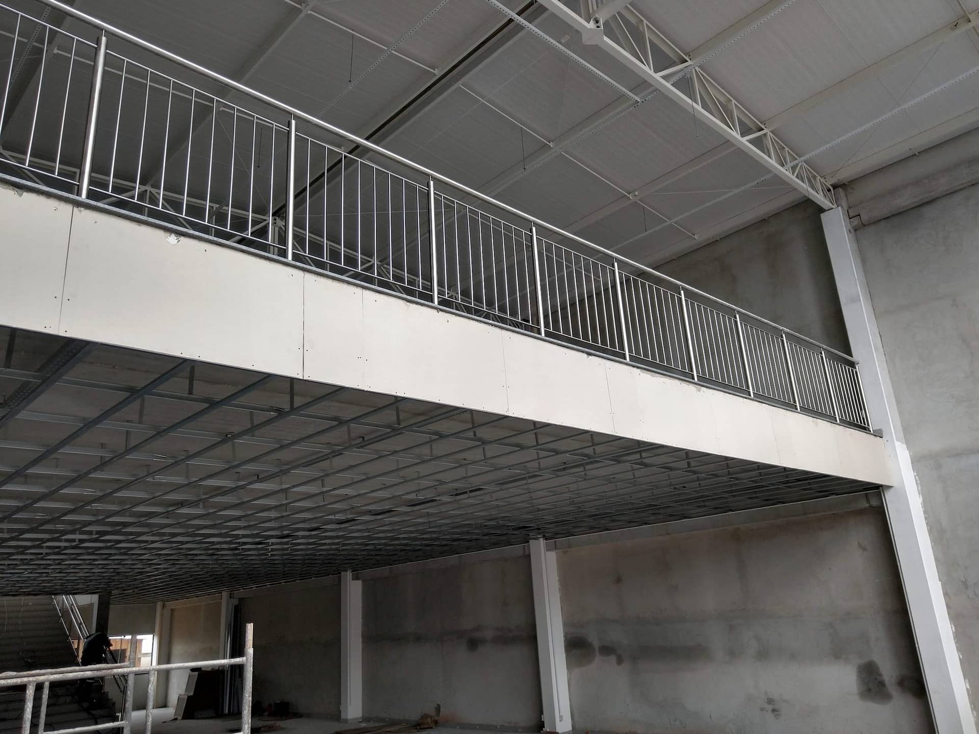 Guarda-corpo de travessas verticais em inox no mezanino, visto de baixo