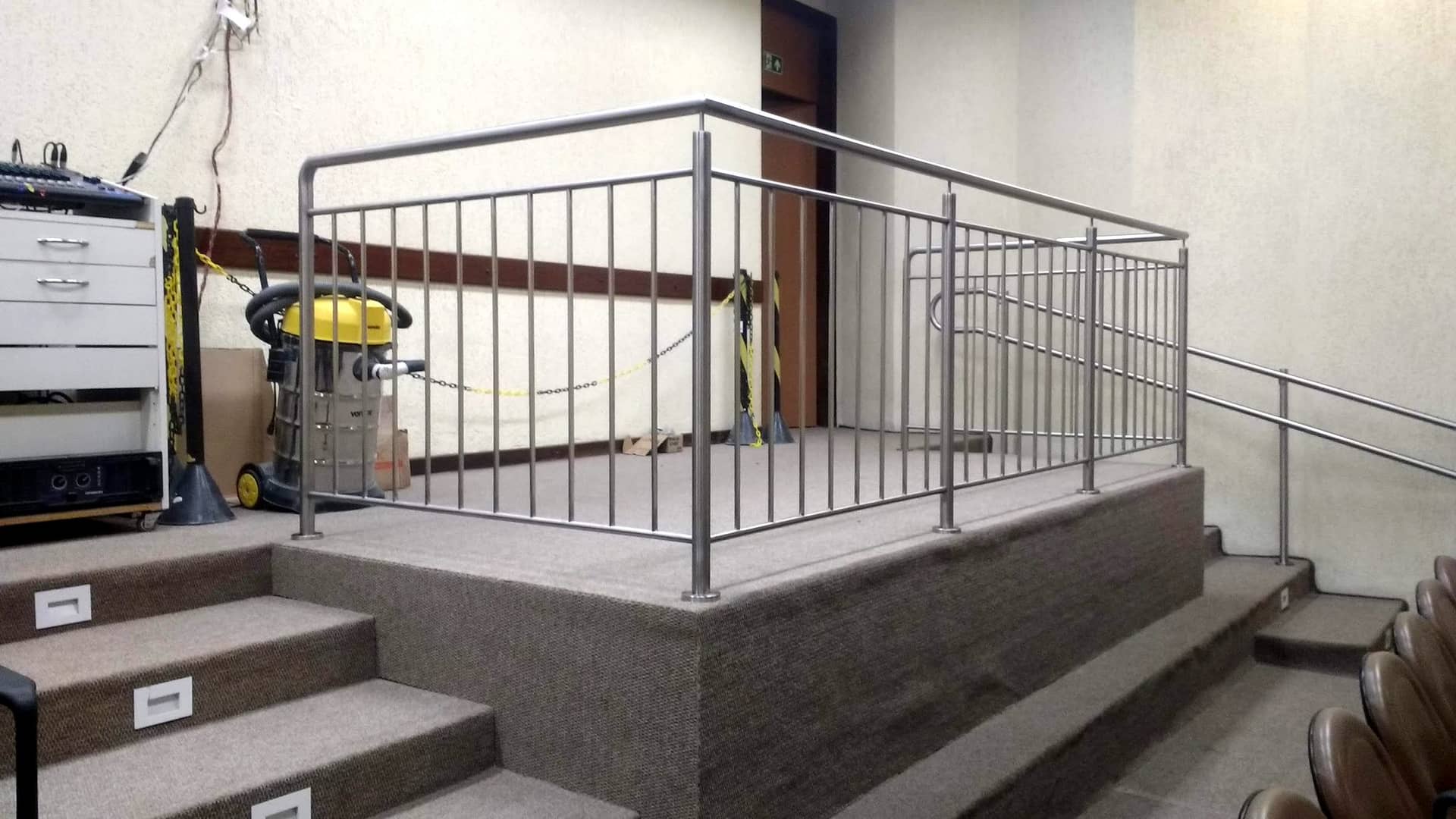 Guarda-corpo de inox no contorno do palco, com a escada lateral