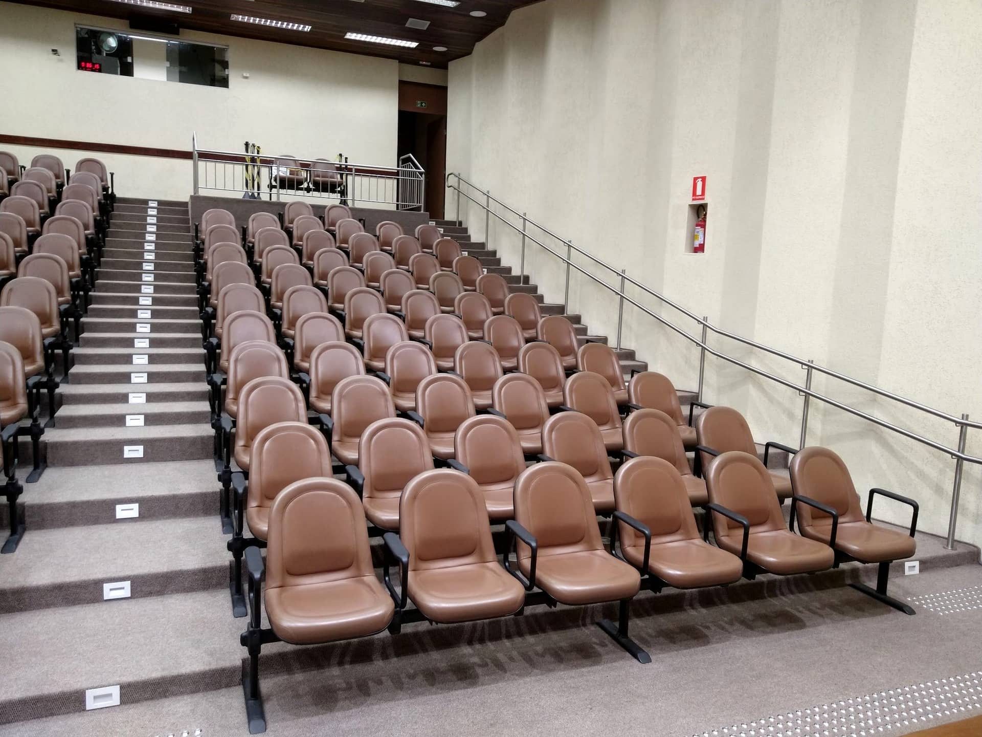 Plateia de auditório com corrimão em inox acompanhando os degraus laterais