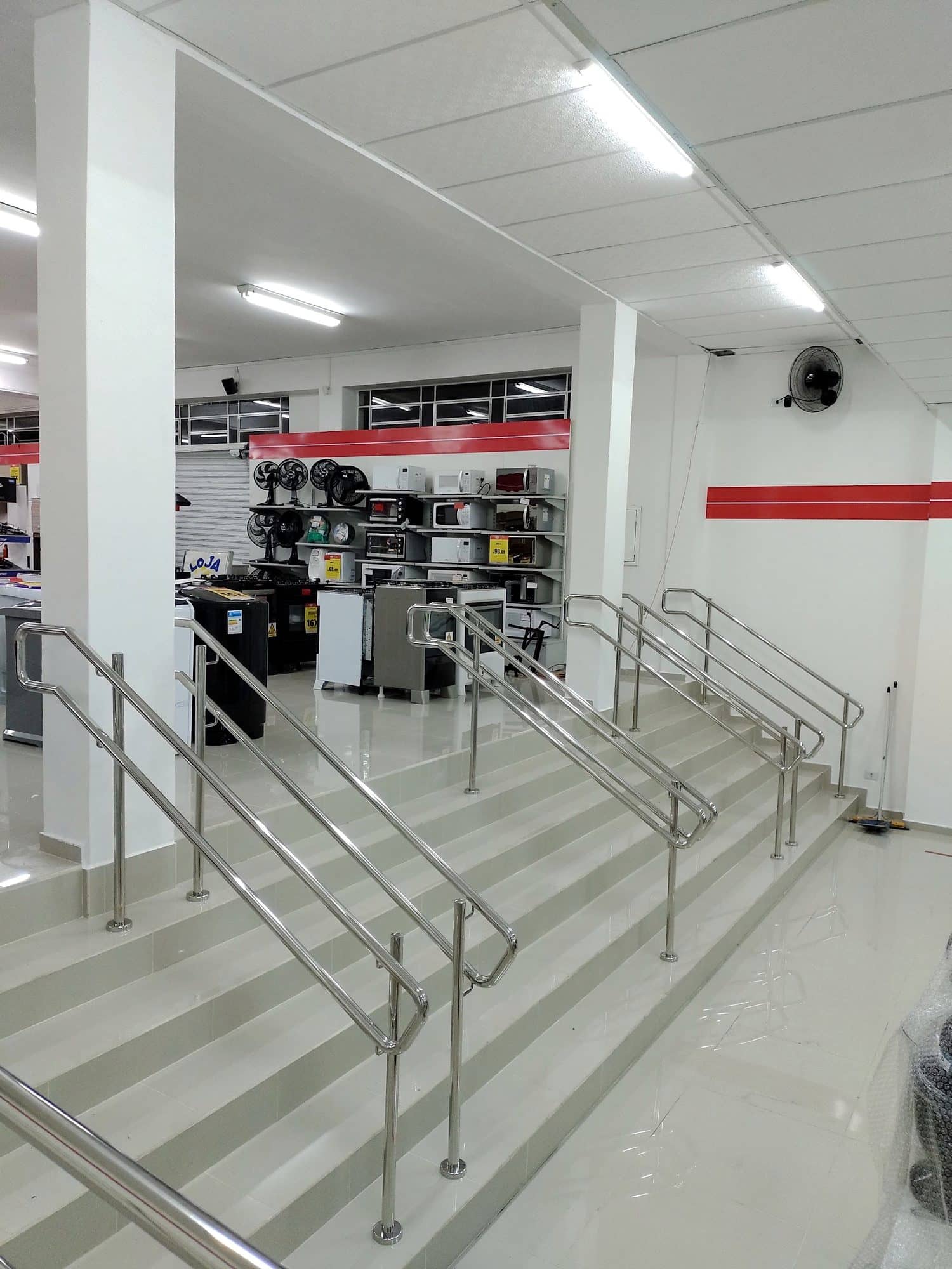 Escada com corrimãos em inox ao lado da rampa, vista de baixo
