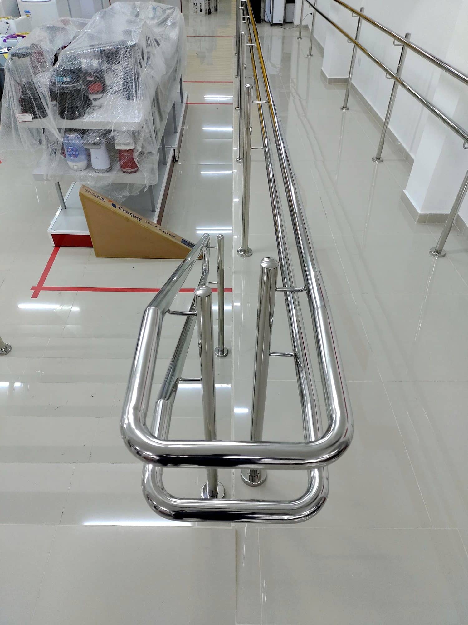 Ponta curva do corrimão duplo em inox no início da rampa