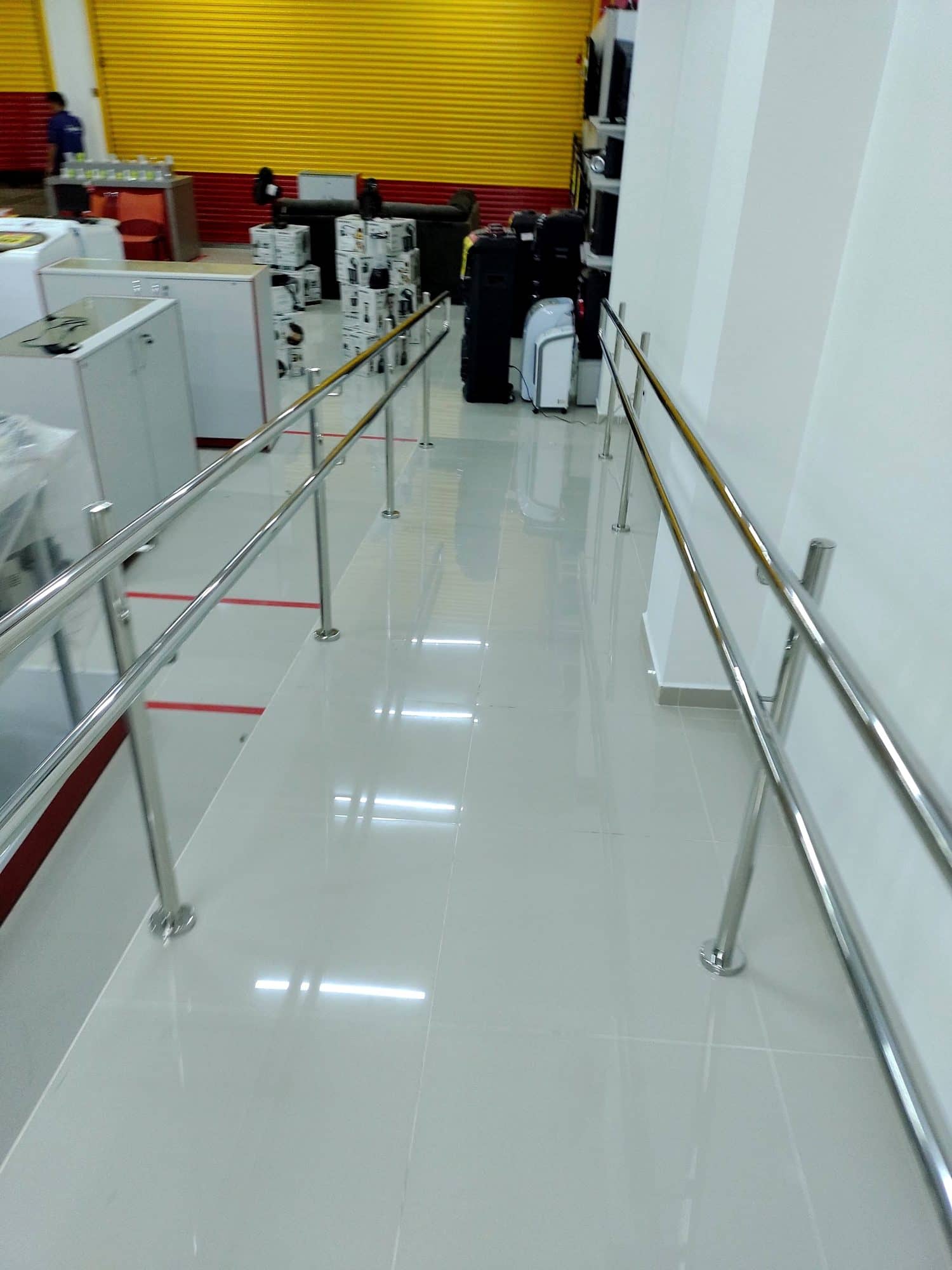 Corredor da rampa com corrimão duplo em inox dos dois lados