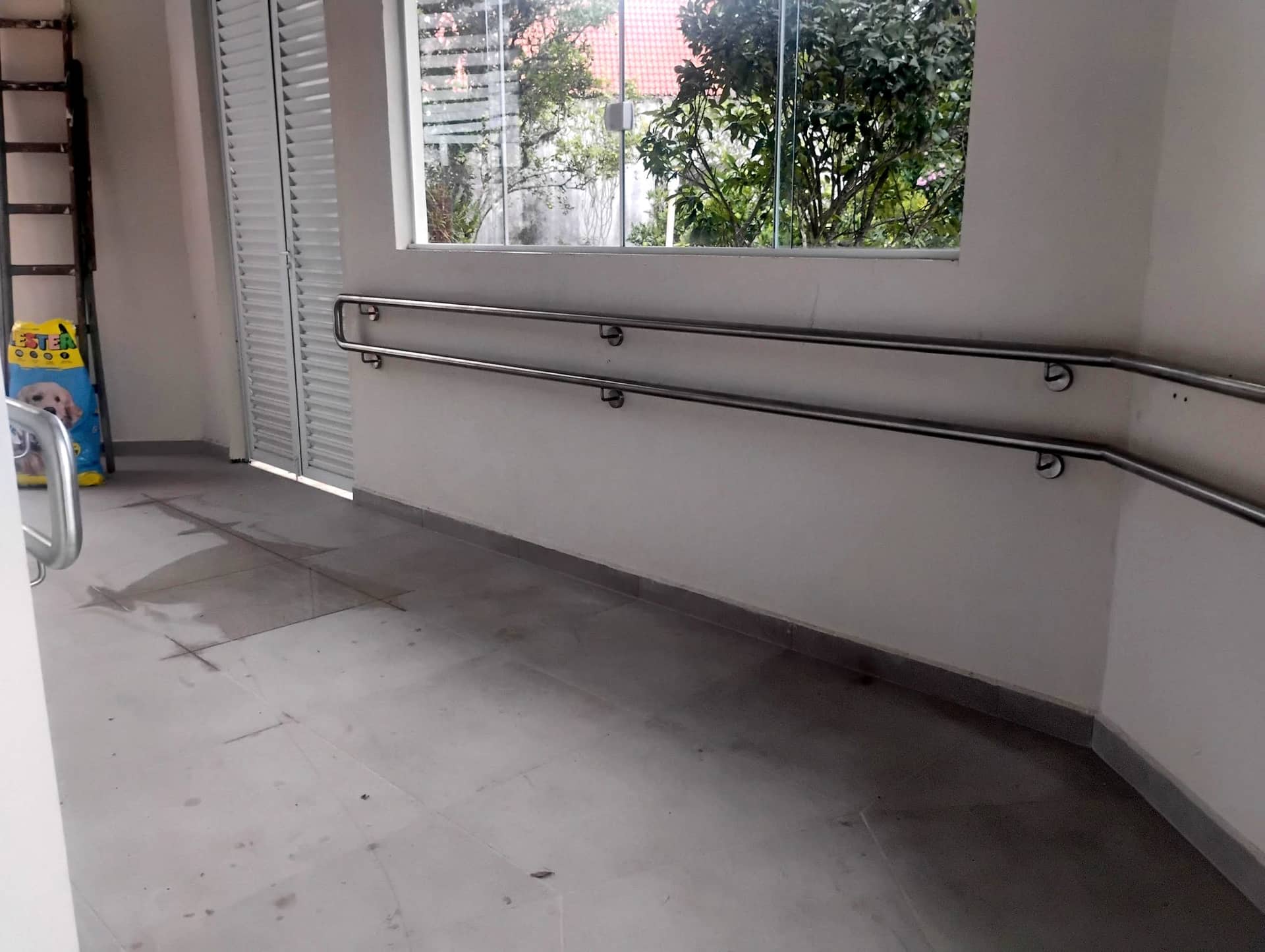 Corrimão duplo de parede em inox fazendo a curva no fim da rampa