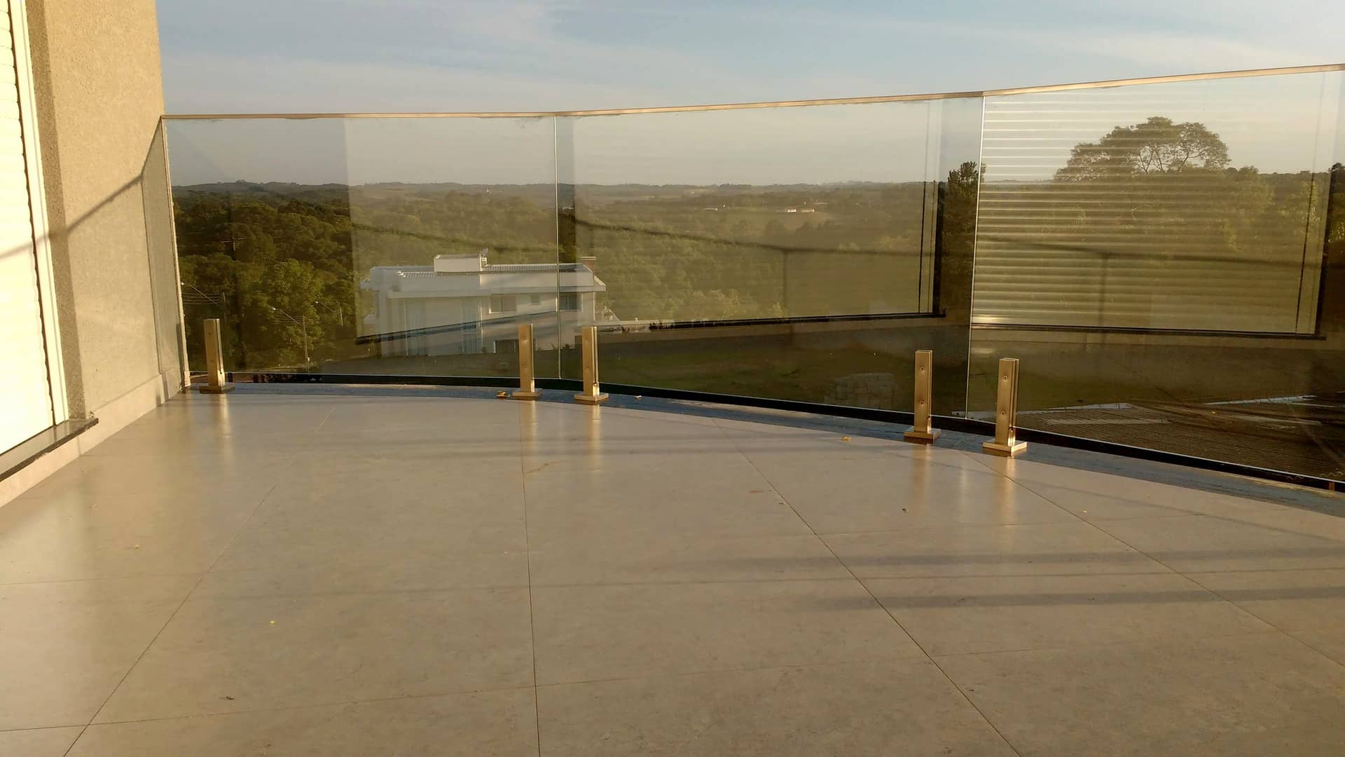 Terraço com guarda-corpo de vidro e vista aberta
