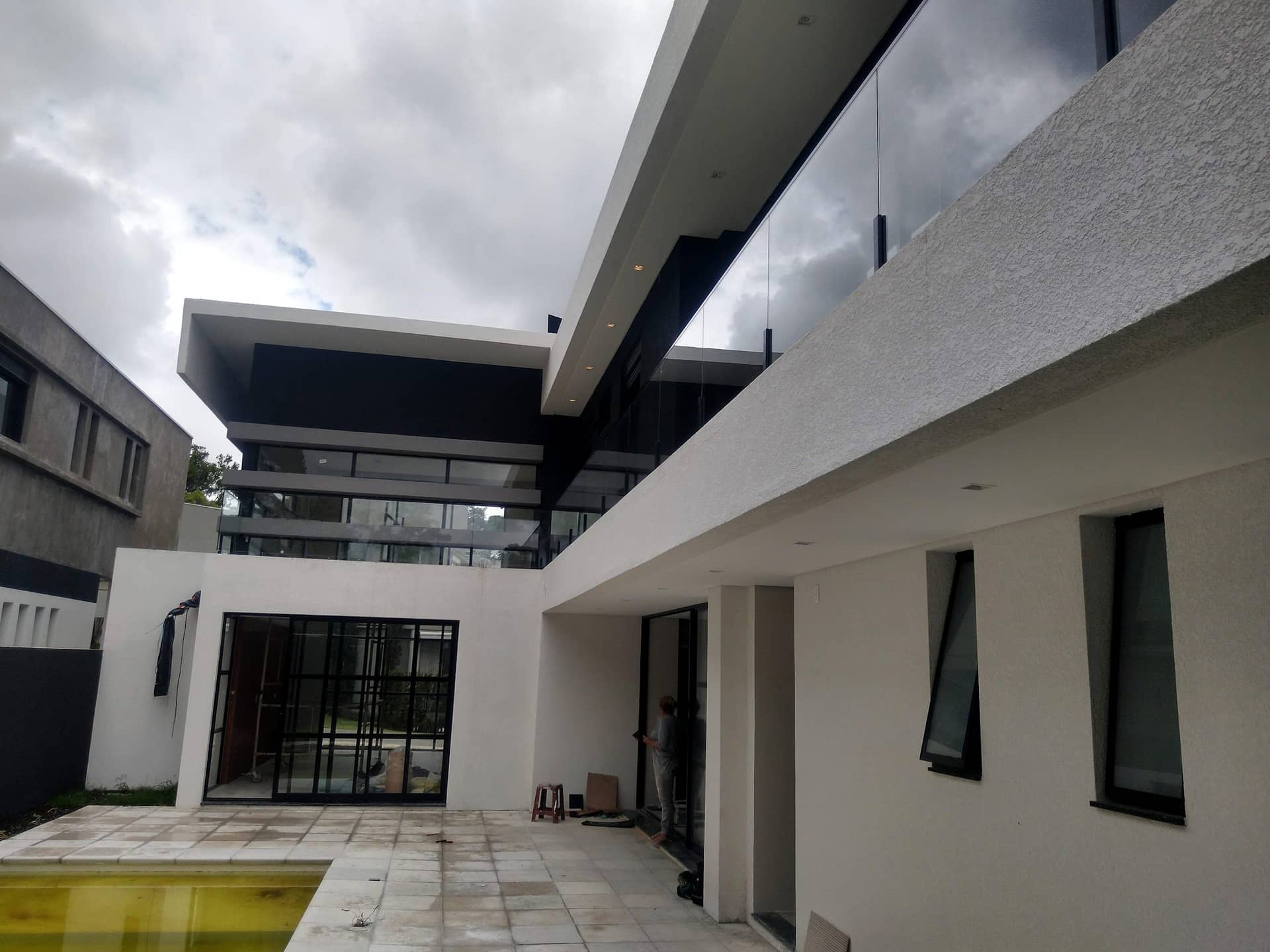 Pátio interno com passarela e guarda-corpo de vidro