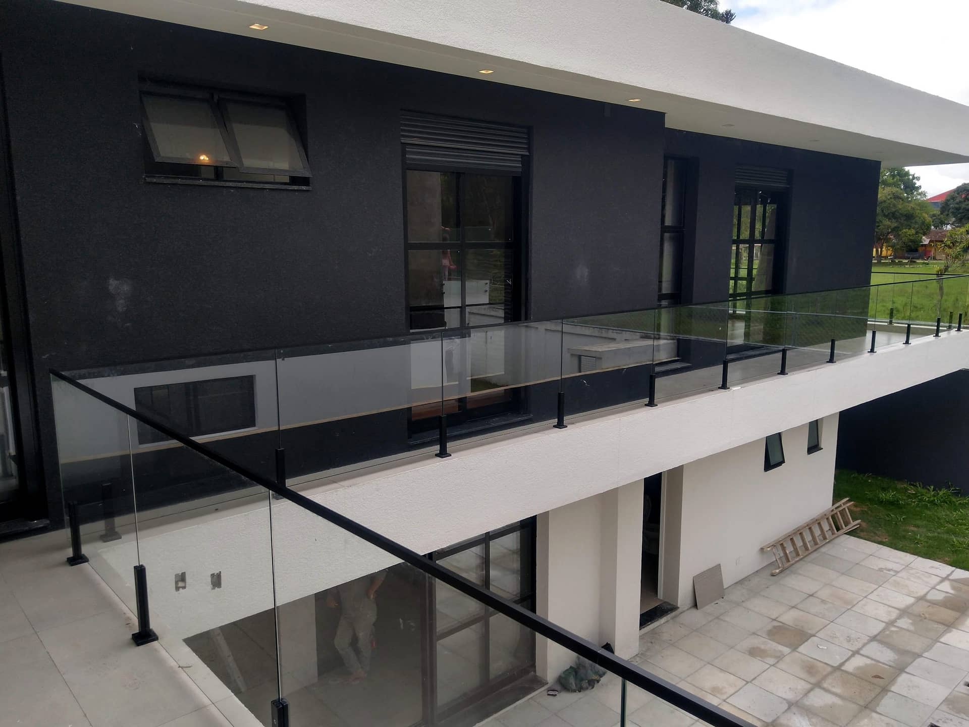 Guarda-corpo de vidro com colunas pretas ao longo do pavimento superior