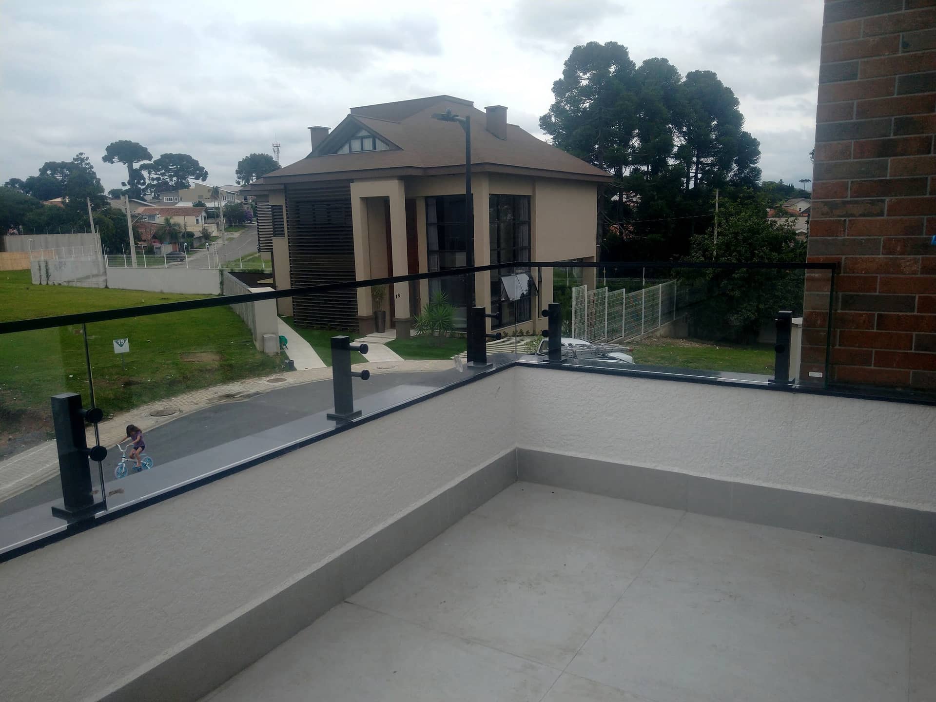 Terraço com guarda-corpo de vidro e vista para o bairro