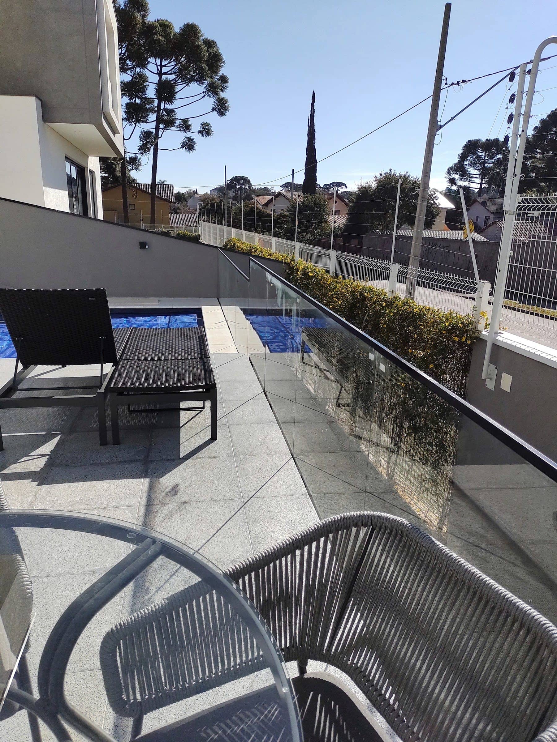 Área da piscina com guarda-corpo de vidro acompanhando a borda do terraço