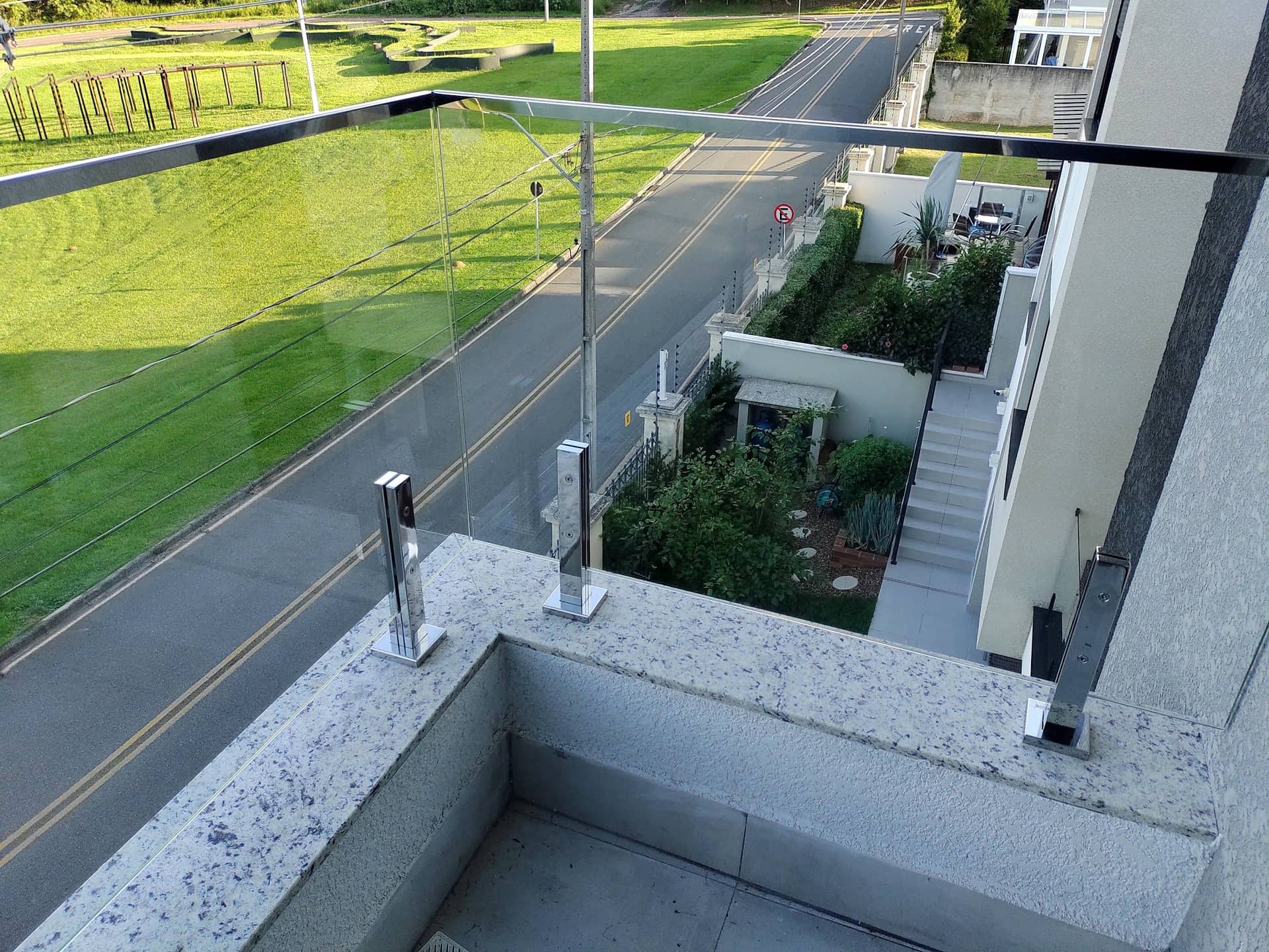 Canto da varanda com colunas em inox fixadas na mureta de granito