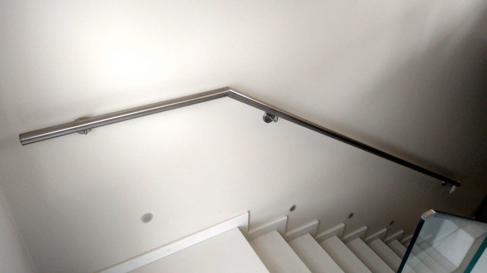 Corrimão de parede em inox fazendo a curva no patamar