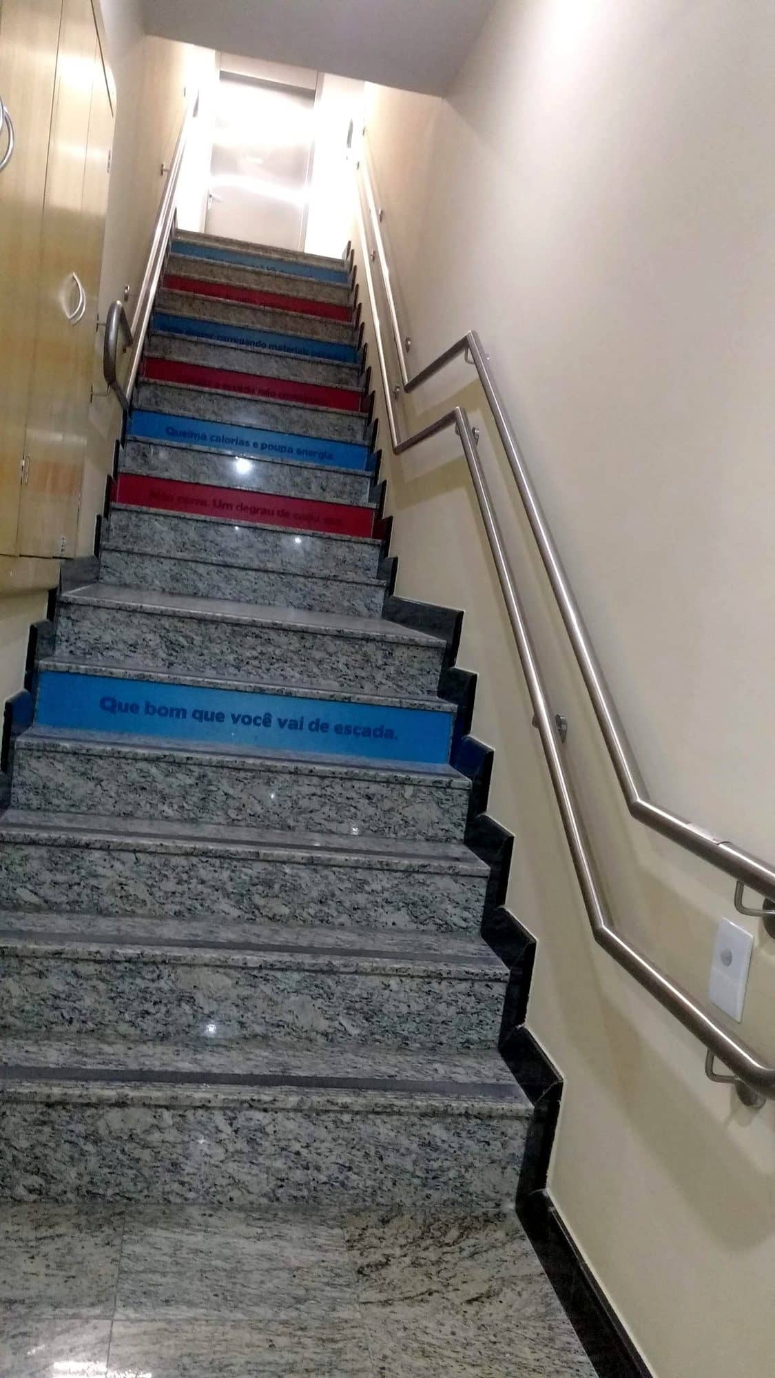 Corrimãos de parede em inox dos dois lados de uma escada de granito