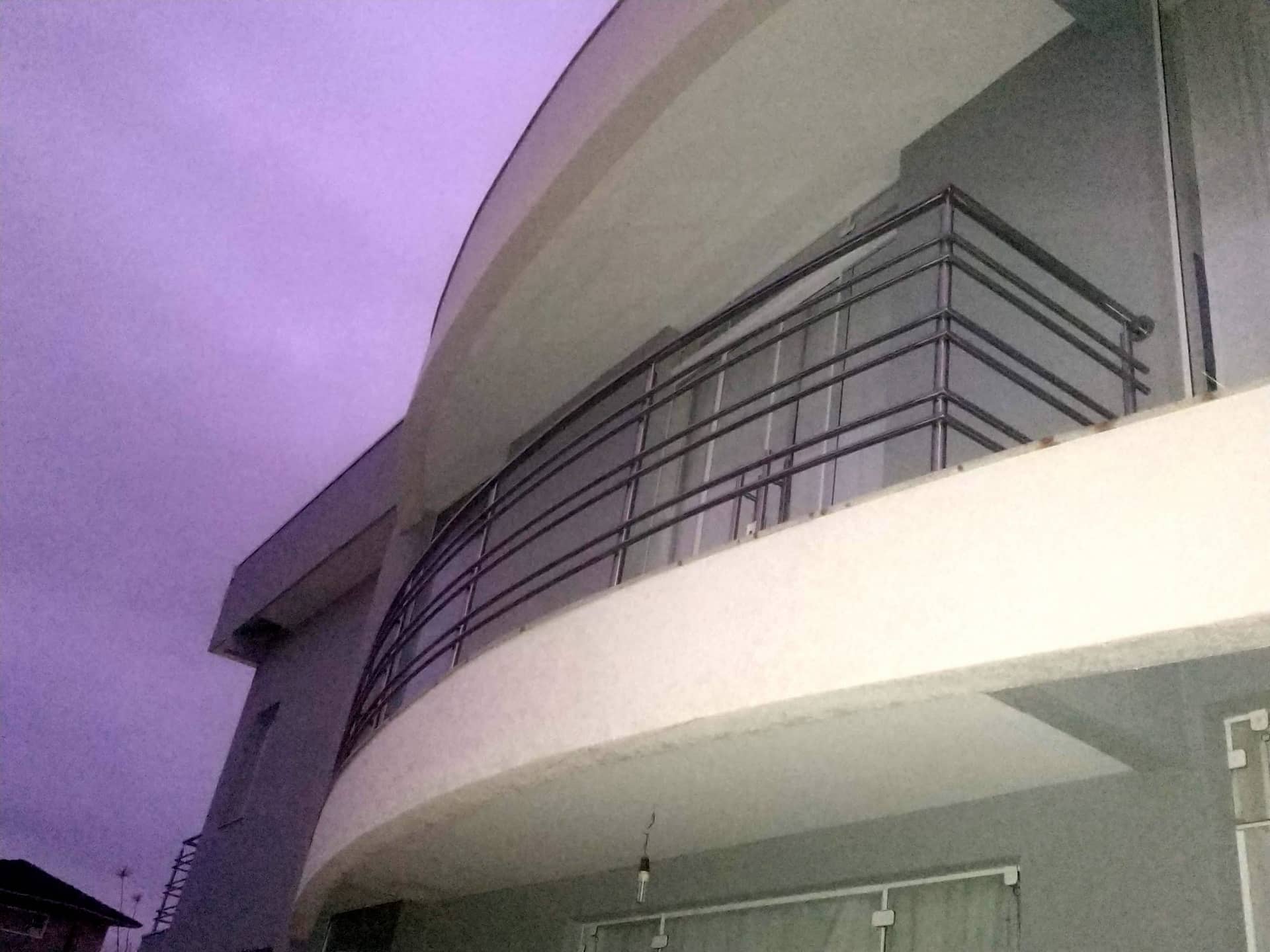 Sacada curva com guarda-corpo de hastes horizontais em inox