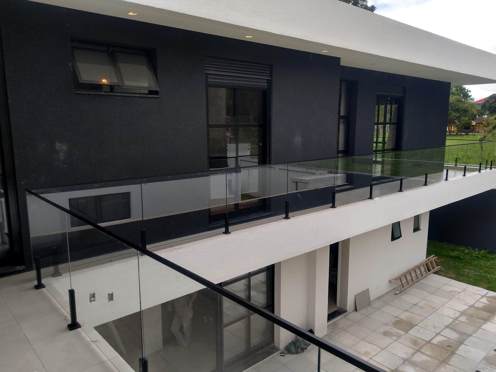 Guarda-corpo de vidro com colunas pretas ao longo do pavimento superior